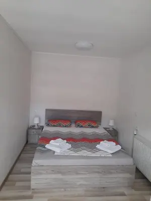 a white bedroom with a bed with wooden floors at Guest Rooms IDeR in Sapareva Banya