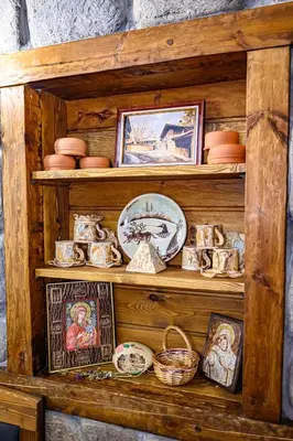 a wooden shelf with dishes and pictures on it at Къща за гости Плевнята in Bansko