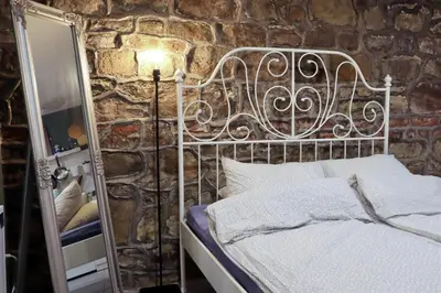 a bed in a room with a stone wall at Sofia Center Cave in Sofia
