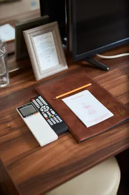 a desk with a remote control and a cell phone at Flamingo Plovdiv in Plovdiv