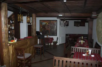 a restaurant with a bar and tables and chairs at Hotel Old Times in Asenovgrad