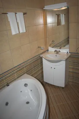 a bathroom with a white tub and a sink at Hotel Old Times in Asenovgrad