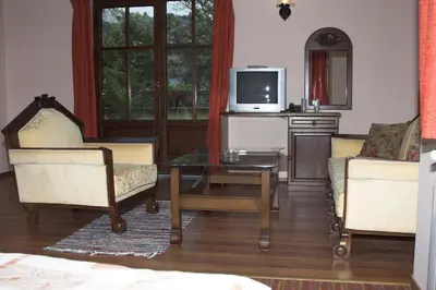 a living room with two chairs and a coffee table at Hotel Old Times in Asenovgrad