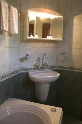 a bathroom with a sink and a toilet and a mirror at Hotel Old Times in Asenovgrad