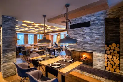 a restaurant with a fireplace and tables and chairs at Vila 6aTo Hotel & Wellnes in Sofia