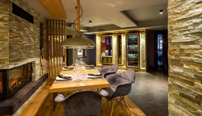 a dining room with a fireplace and a table and chairs at Vila 6aTo Hotel & Wellnes in Sofia