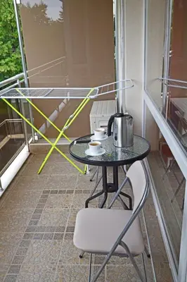 a small table with a tea kettle on a balcony at Хисаря ВИП апартаменти in Hisarya