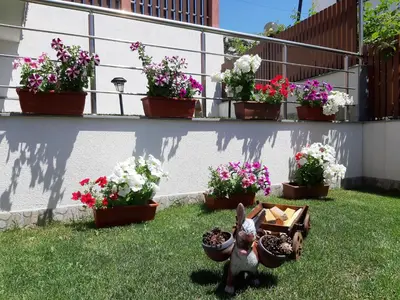 a garden with flowers and a statue of a rabbit at Къща за гости Романс in Yagodina