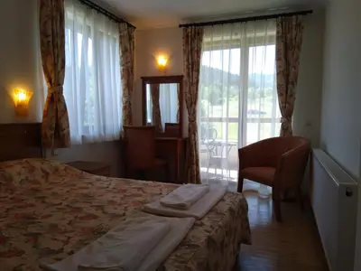 a hotel room with a bed and a window at Вила Цветелина, Комплекс Александриa in Dobrinishte