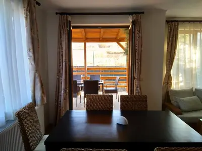 a dining room with a table and chairs and a window at Вила Цветелина, Комплекс Александриa in Dobrinishte