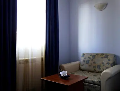 a living room with a chair and a table at Комплекс Белвю - Банкя in Bankya