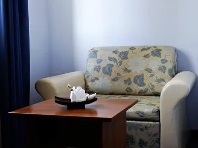 a living room with a chair and a table with a white horse statue on at Комплекс Белвю - Банкя in Bankya