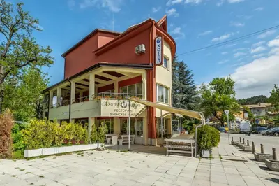 a red building with a bench in front of it at Комплекс Белвю - Банкя in Bankya