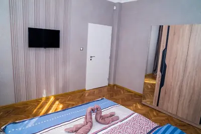 a bedroom with two slippers on a bed at Sofia Central Luxury Apartment in Sofia