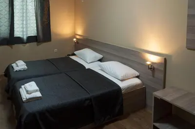 a bedroom with a bed with two towels on it at Family Hotel Pautalia in Sandanski