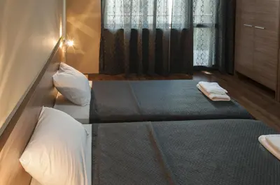 a bedroom with two beds and a window at Family Hotel Pautalia in Sandanski
