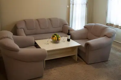 a living room with two couches and a table with fruit at Family Hotel Pautalia in Sandanski