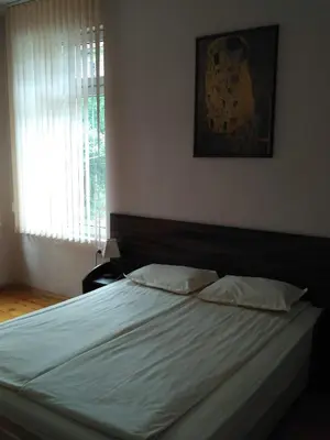 a bedroom with a bed with white sheets and a window at семеен хотел 