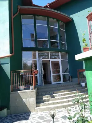 a green building with a front door and stairs at семеен хотел 