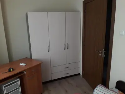 a large white cabinet in a room with a desk at Guest House Mania in Sofia
