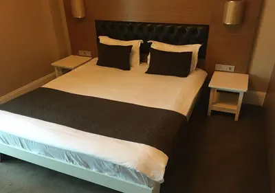 a bedroom with a large bed with two tables at City Hotel Plovdiv FREE PARKING in Plovdiv