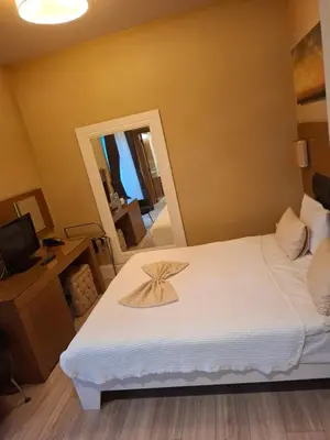 a bedroom with a large white bed with a mirror at City Hotel Plovdiv FREE PARKING in Plovdiv