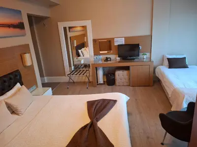 a hotel room with a bed and a desk with a television at City Hotel Plovdiv FREE PARKING in Plovdiv
