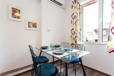 a dining room with a table and chairs and a window at Top center big family apartment with garden view in Plovdiv