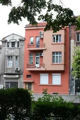 a pink building with a balcony on the side of it at Top center big family apartment with garden view in Plovdiv