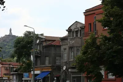 an old building on a street with a statue in the background at Top center big family apartment with garden view in Plovdiv