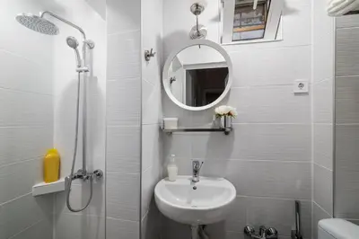 a white bathroom with a sink and a mirror at Urban Garden in Sofia