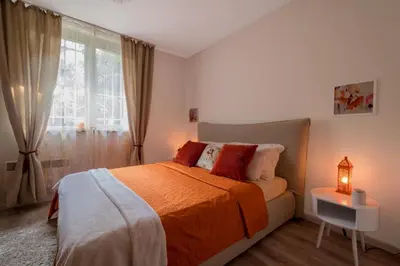 a bedroom with a bed with an orange blanket and a window at Urban Garden in Sofia