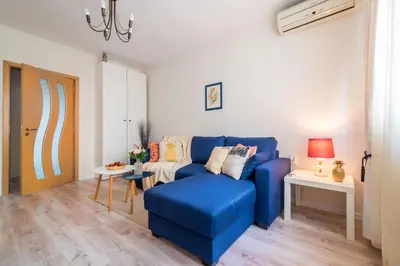 a living room with a blue couch and a table at Urban Garden in Sofia