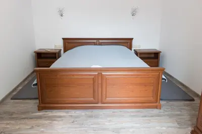 a bed in a room with a wooden bed frame at Apartments Nasini by Flat Mаnager in Plovdiv