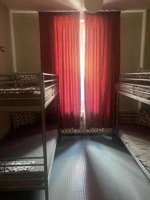 a room with two bunk beds and a window with red curtains at Bla Bla Hostel in Sofia