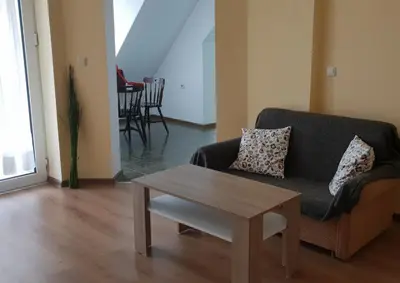 a living room with a couch and a coffee table at Апартамент за нощувки in Gotse Delchev