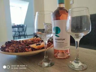 a bottle of wine and two glasses on a table at Апартамент за нощувки in Gotse Delchev