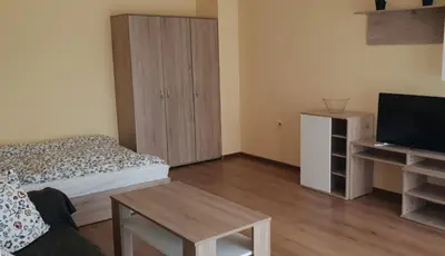 a bedroom with a bed and a cabinet and a television at Апартамент за нощувки in Gotse Delchev