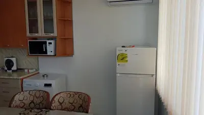 a kitchen with a white refrigerator and two chairs at Д и В 2 - D & V 2 Apartment in Sandanski