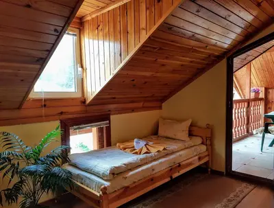 a bedroom in a log cabin with a bed at Къща за гости 