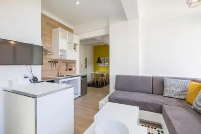a living room and kitchen with a couch and a table at blueWaveplace - Contemporary Home in Center of Sofia in Sofia
