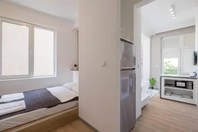 a white bedroom with a bed and a window at blueWaveplace - Contemporary Home in Center of Sofia in Sofia