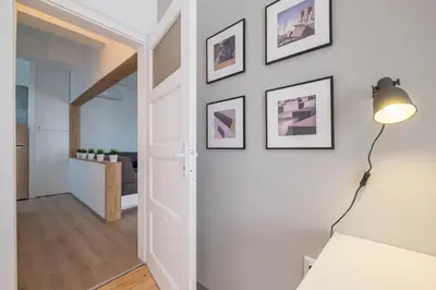a white hallway with a lamp and pictures on the wall at blueWaveplace - Stylish 2 BR Home in Center of Sofia in Sofia