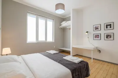 a white bedroom with a large bed and a desk at blueWaveplace - Stylish 2 BR Home in Center of Sofia in Sofia