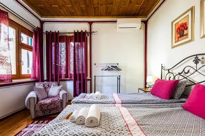 a bedroom with two beds and a chair at Blacksmith's House - Old Town in Plovdiv