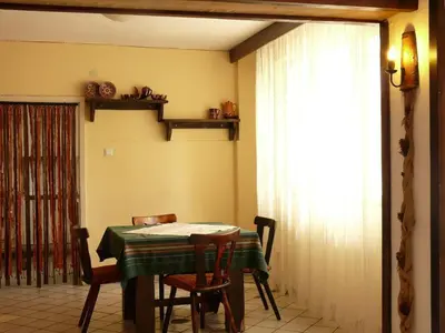 a dining room with a table and chairs and a window at Почивна станция Витоша in Velingrad