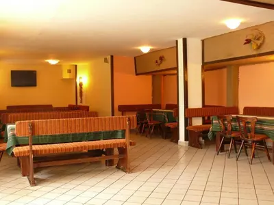 a restaurant with wooden benches and tables and chairs at Почивна станция Витоша in Velingrad