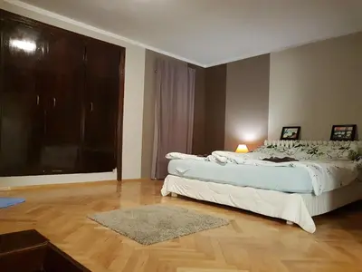 a bedroom with two beds and a large window at Artistic studio in Sofia's top center in Sofia