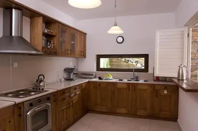 a large kitchen with wooden cabinets and a window at The Reddoorshouse in Solishta
