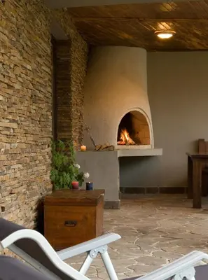 a fireplace in a living room with a pizza oven at The Reddoorshouse in Solishta